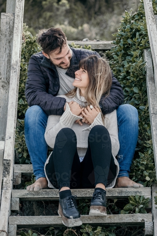 Hip young couple on steps at the beach. - Australian Stock Image