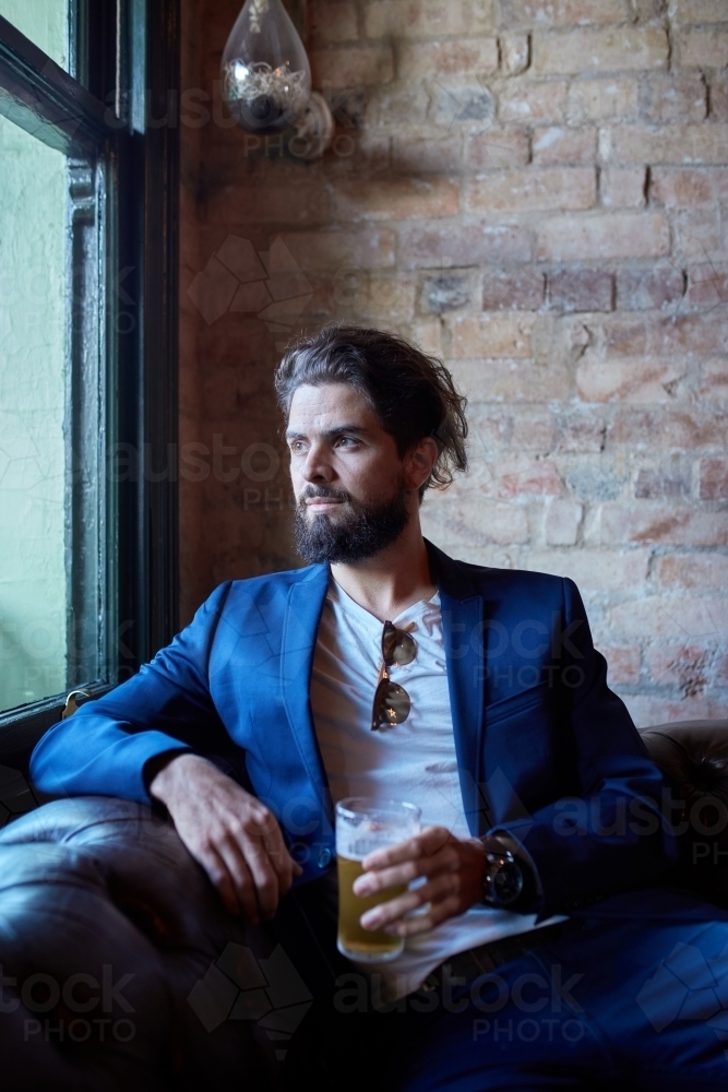 Hipster man enjoying drinking a beer at pub - Australian Stock Image