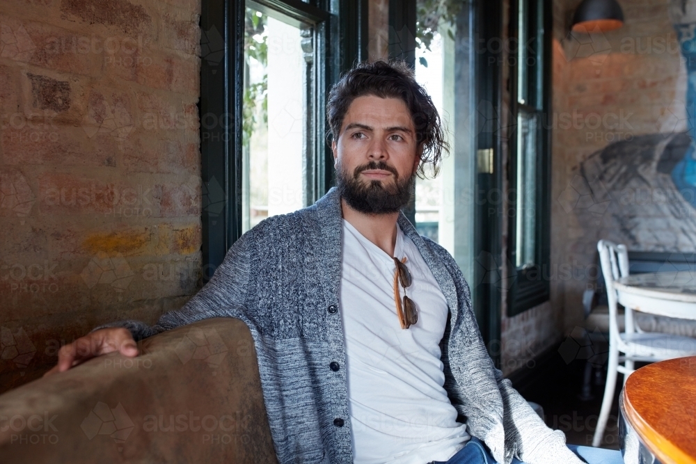 Hipster man enjoying drinking a beer at pub - Australian Stock Image
