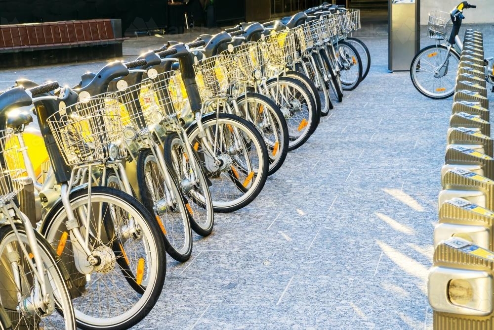Hire bikes lined up in a row on a city street - Australian Stock Image