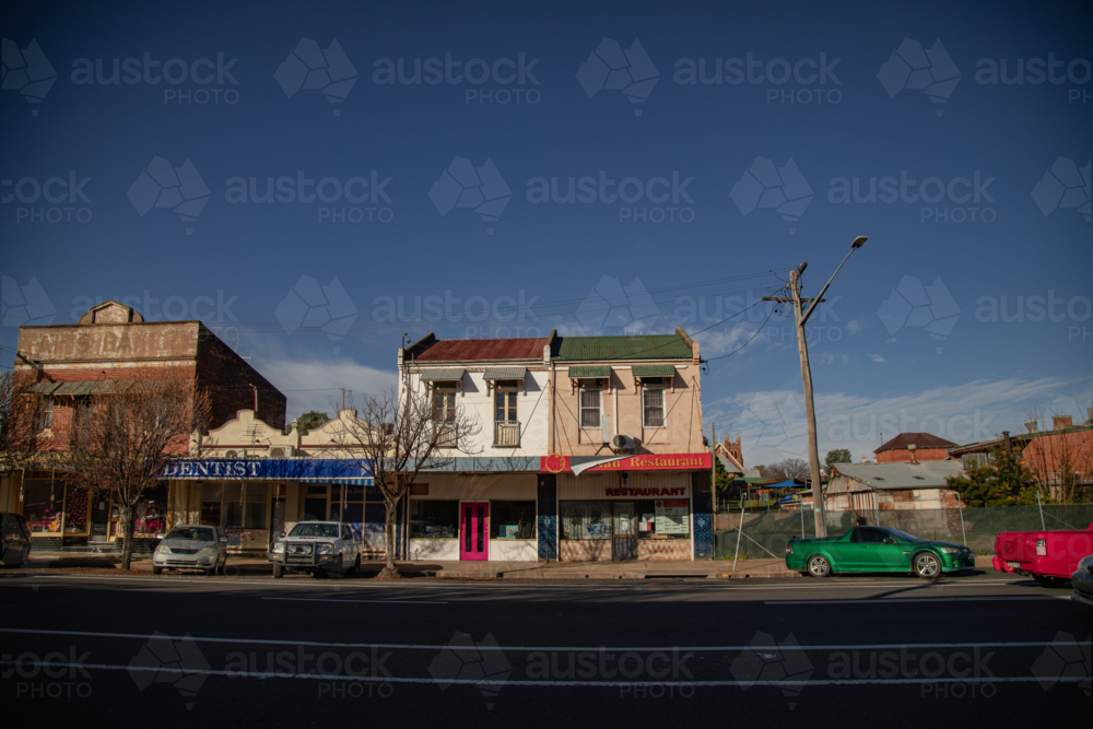 Historic Australian main street with vintage buildings and parked cars under a clear blue sky - Australian Stock Image