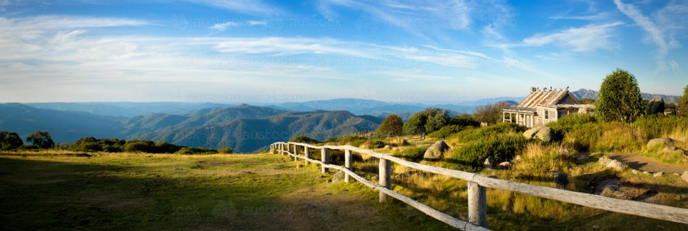 Historic mountain hut overlooking endless blue ranges. - Australian Stock Image