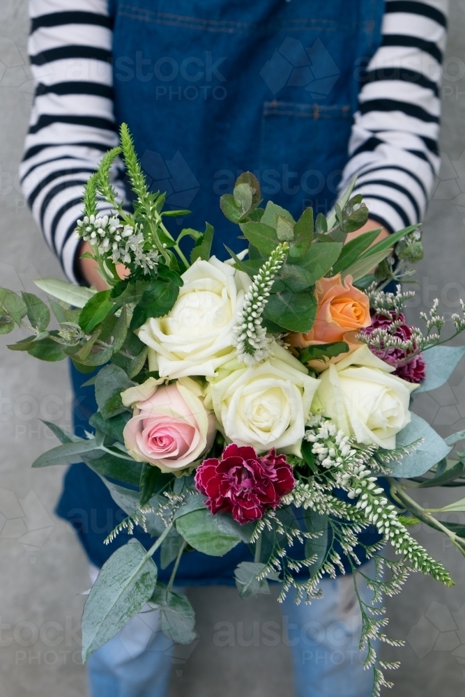Holding a bright bunch of flowers - Australian Stock Image