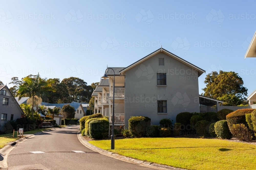 holiday cottage beside narrow road with hedges around building - Australian Stock Image