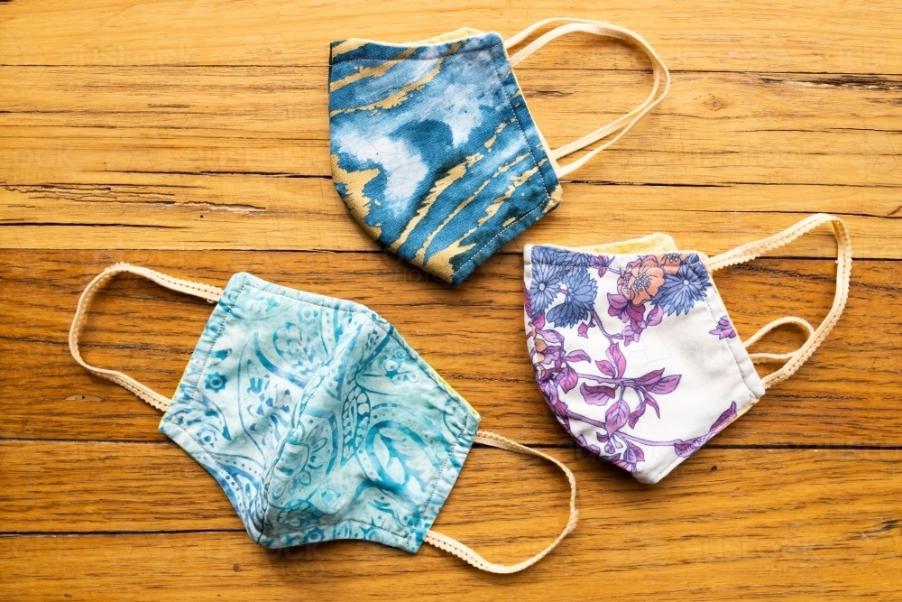 Home made fabric face masks used during the coronavirus COVID-19 pandemic. masks are on wood - Australian Stock Image