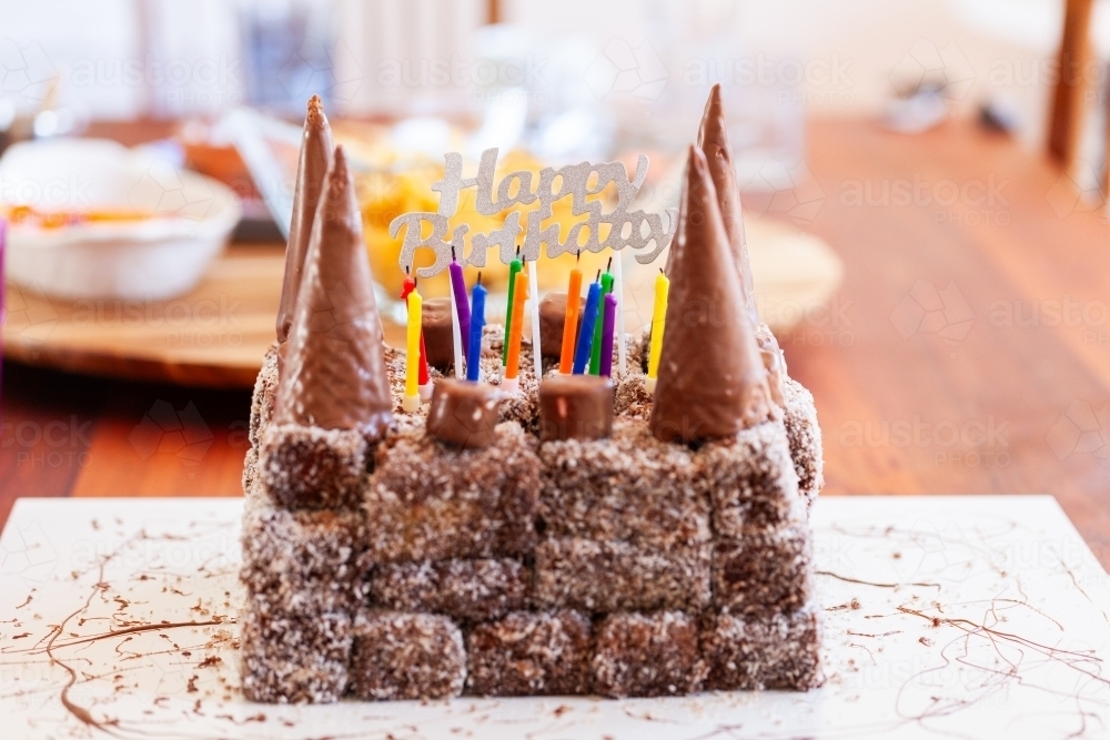 homemade castle birthday cake made of lamington bricks with chocolate cone turrets - Australian Stock Image