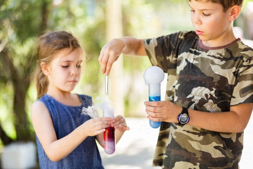 Homeschooled children doing science experiment with dry ice, water and soap - Australian Stock Image
