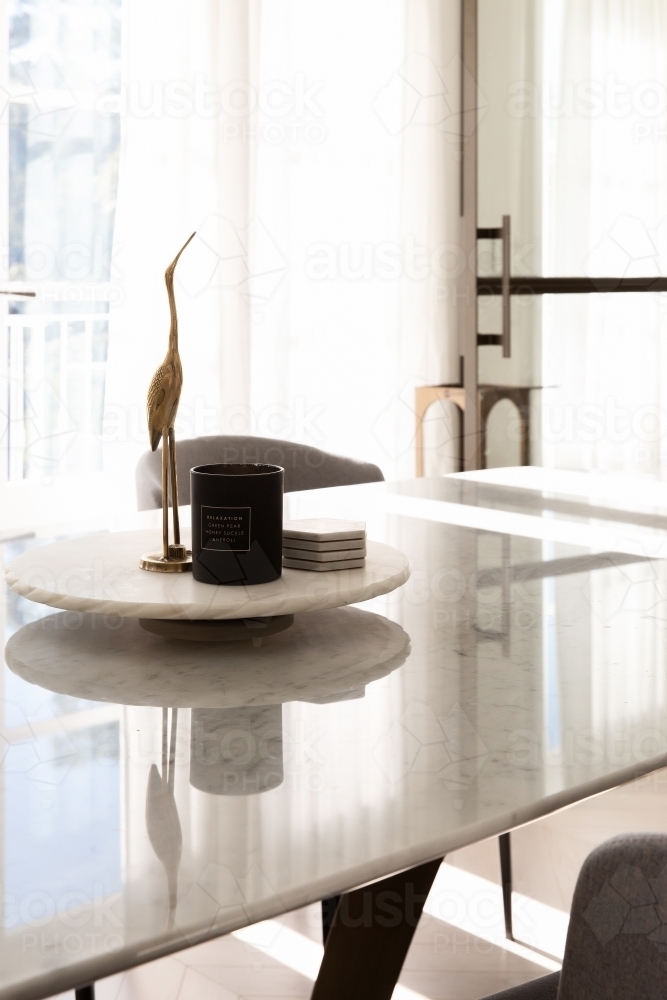 Homewares on marble dining table with brass accents and decorations - Australian Stock Image