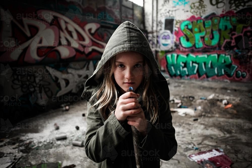 Hooded girl holding a pipe with attitude - Australian Stock Image