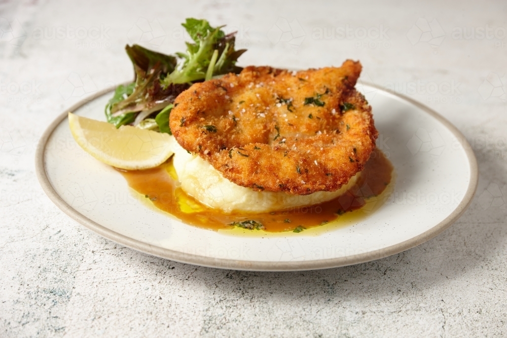 A plate of chicken schnitzel with potato mash and gravy - Australian Stock Image