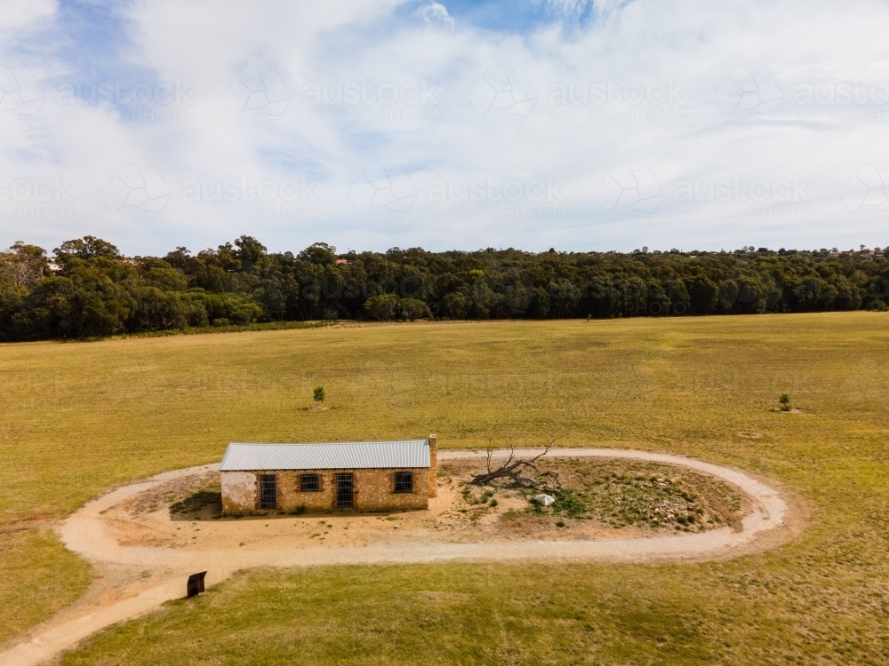 horizontal shot of a barn with a path around it and with trees in the background - Australian Stock Image
