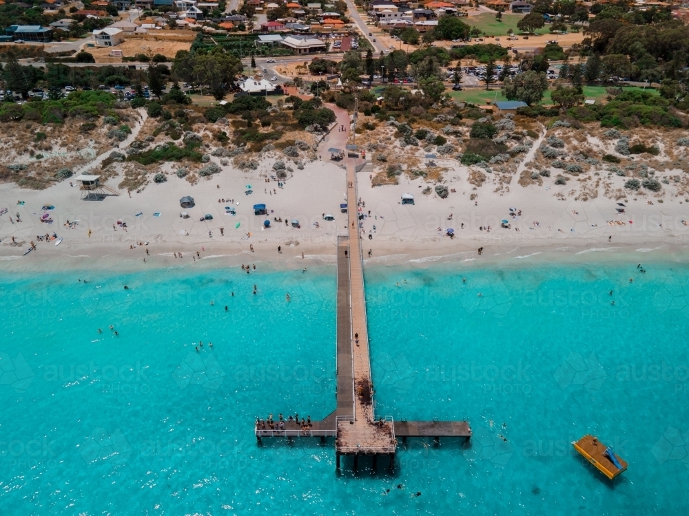 horizontal shot of a beach with wooden walkway, people swimming, buildings, trees and floating ramp, - Australian Stock Image