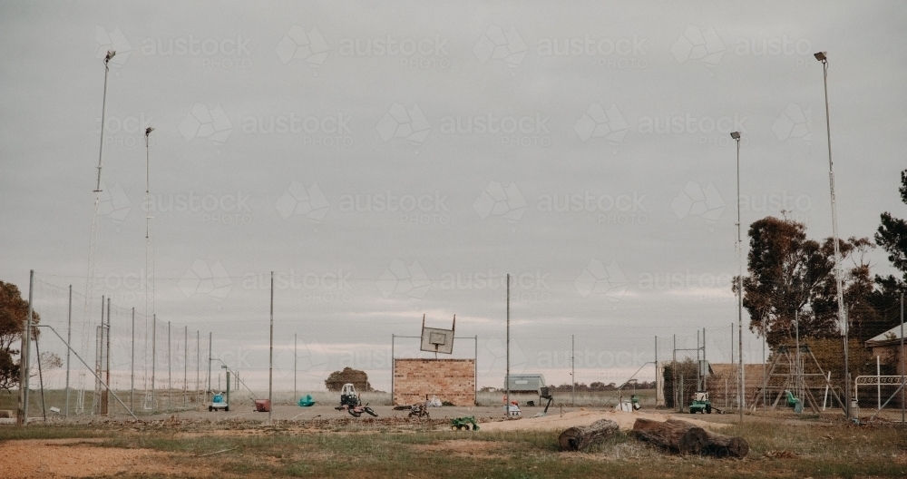 Run down basketball court with abandoned ride on toys - Australian Stock Image