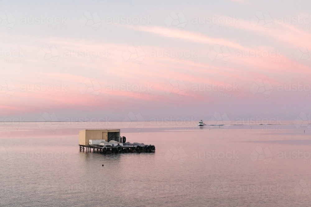 Horizontal shot of a crayfishing boat at sunrise with shack - Australian Stock Image