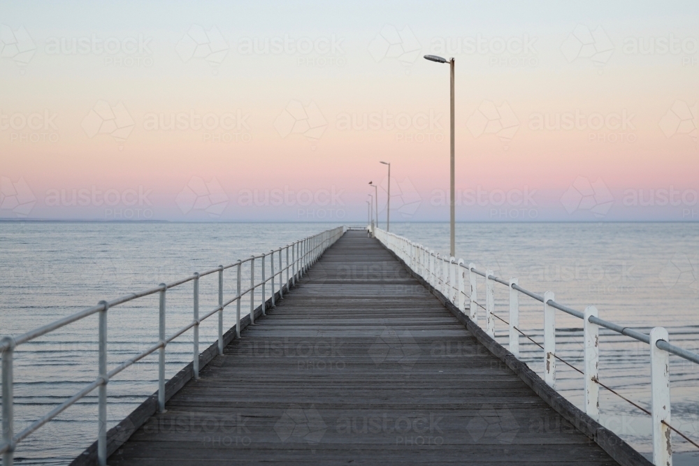 Looking out along a jetty at sunset - Australian Stock Image