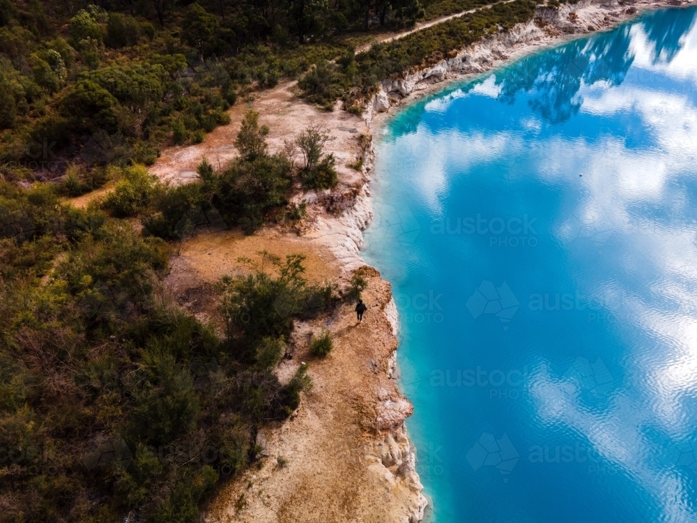 horizontal shot of a lake with sky reflection surrounded  by green trees - Australian Stock Image