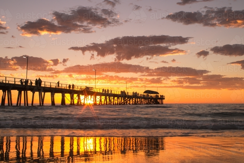 Horizontal shot of a long wharf on the beach at sunset - Australian Stock Image