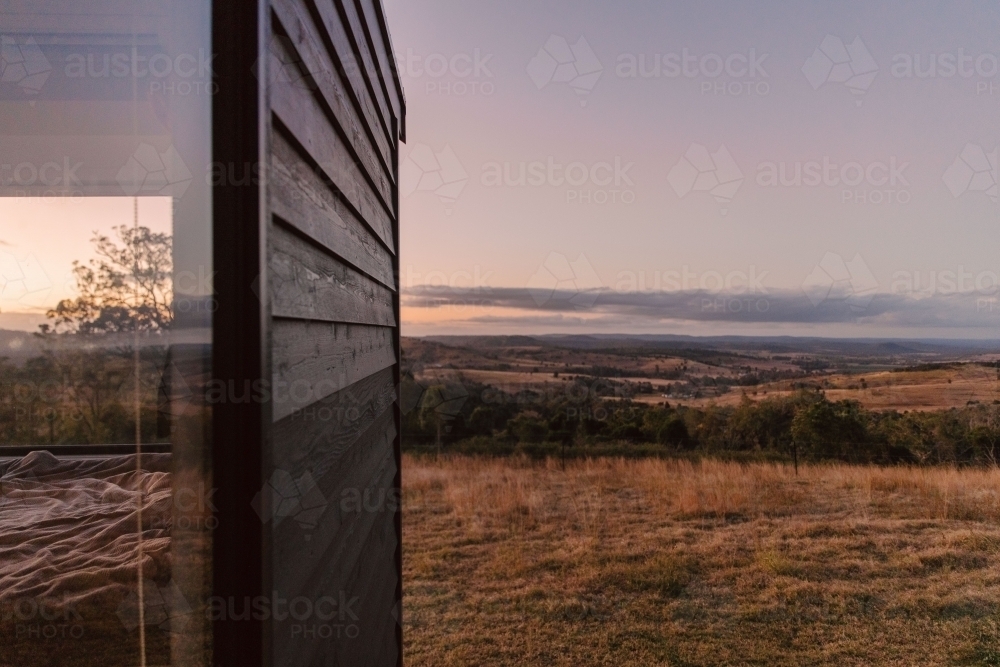 Horizontal shot of a mountain field with trees - Australian Stock Image