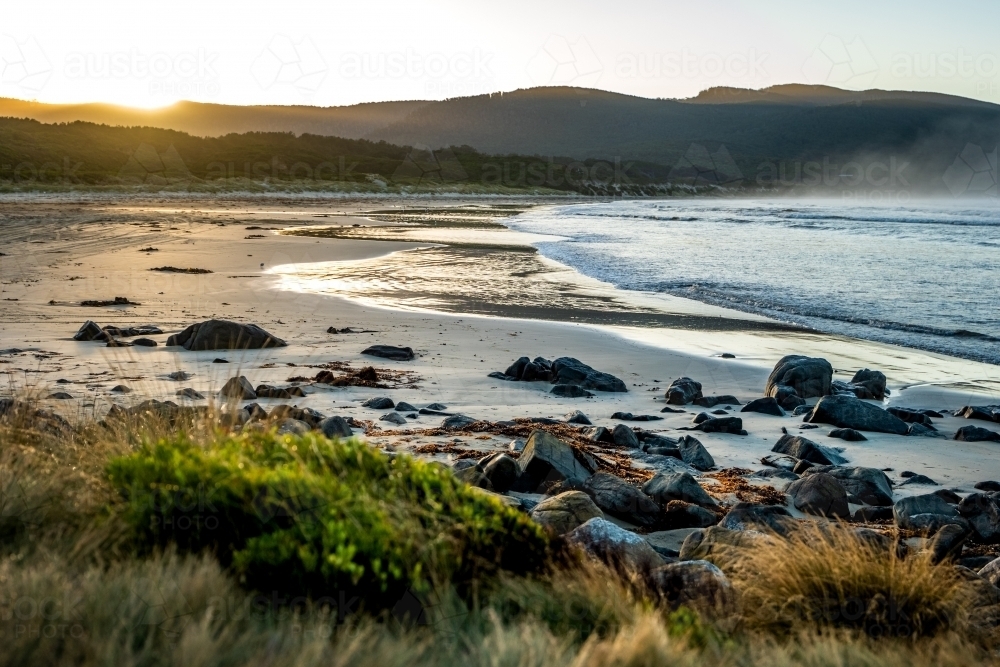 Horizontal shot of a rocky shoreline at sunset - Australian Stock Image