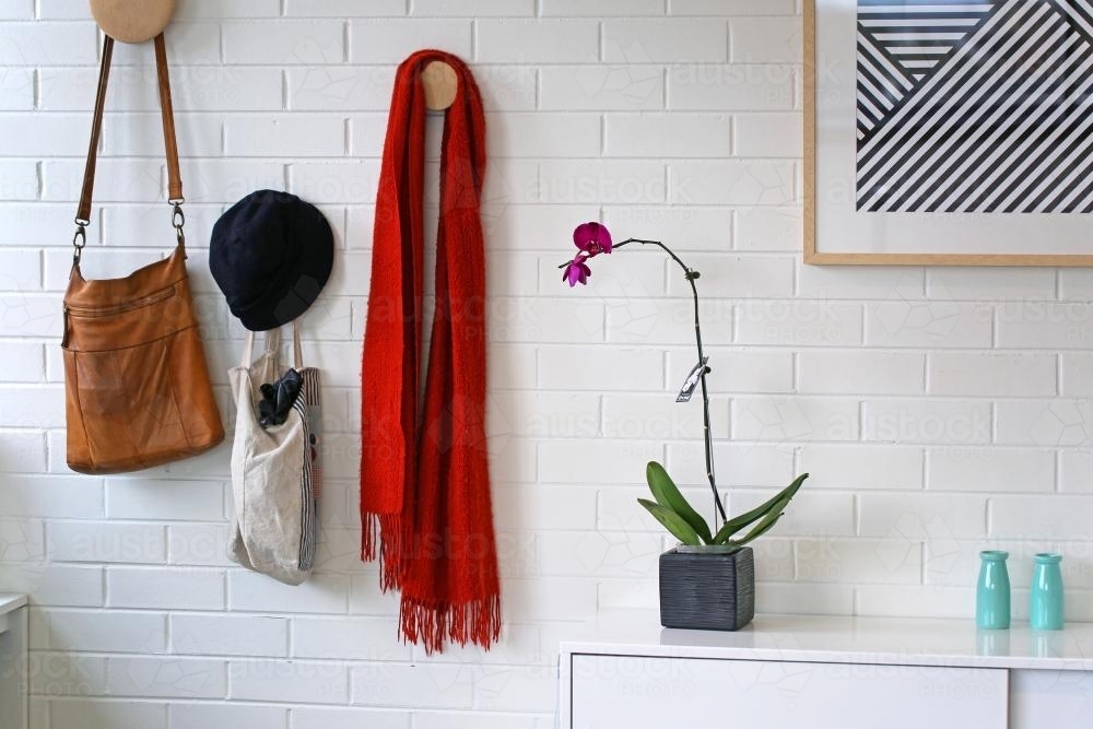 Horizontal shot of a tote bag, scarf and hat hanging on a white wall - Australian Stock Image