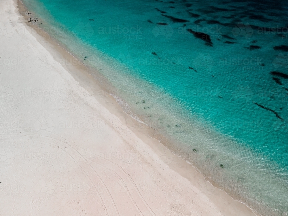 horizontal shot of a white sand beach on a sunny day - Australian Stock Image
