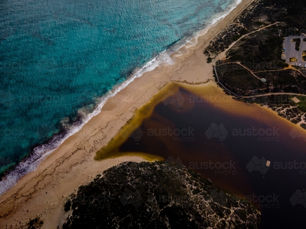 horizontal shot of a white sand beach with bushes, and waves on a sunny day - Australian Stock Image