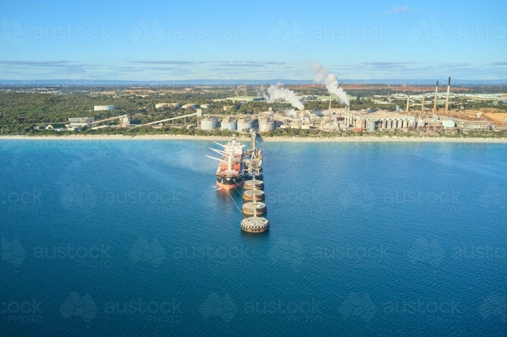 horizontal shot of Kwinana alumina refinery on a sunny day with smoke, industrial area and ship - Australian Stock Image