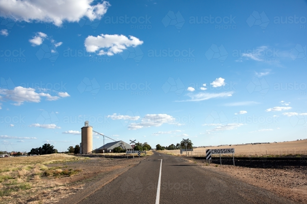 Horizontal shot of an empty road with crossing and railway signage - Australian Stock Image