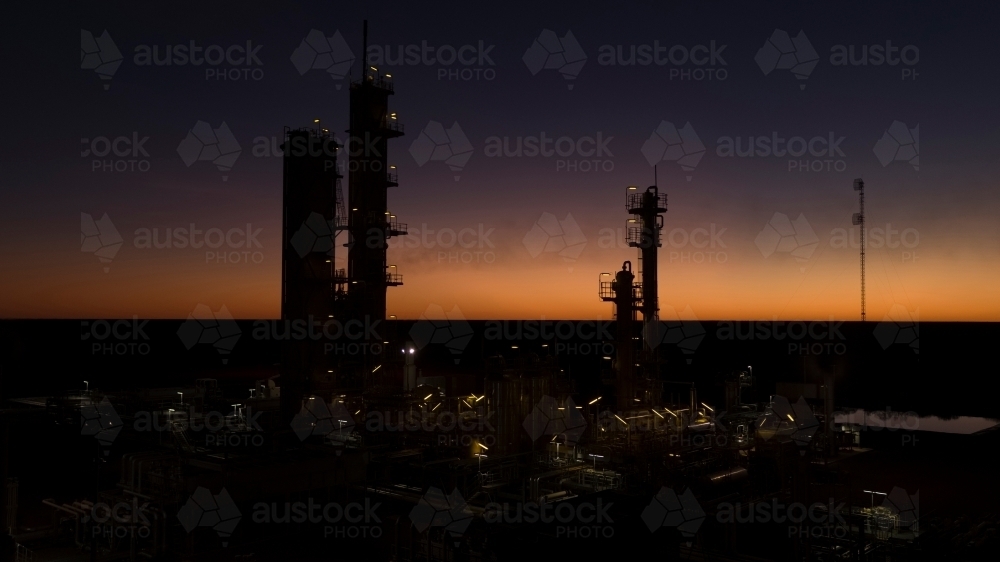 Horizontal shot of an industrial plant approaching sunrise/sunset - Australian Stock Image