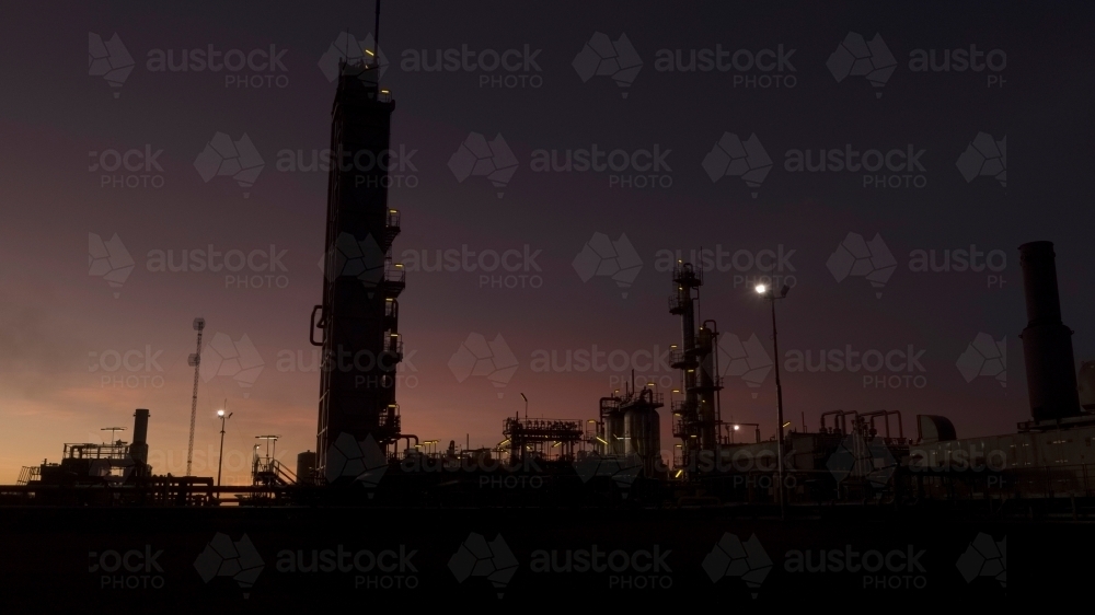 Horizontal shot of an industrial plant approaching sunrise/sunset - Australian Stock Image