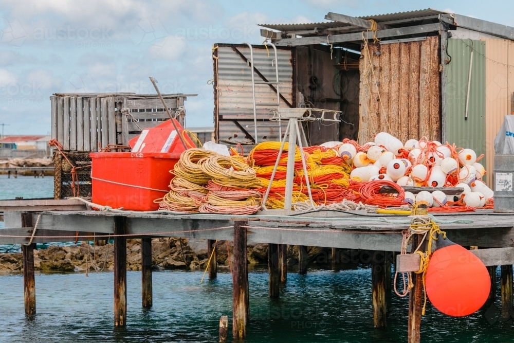 Horizontal shot of commercial cray fishing buoys and rope on a jetty - Australian Stock Image