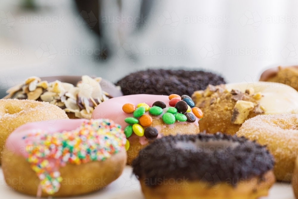 Horizontal shot of donuts with different toppings. - Australian Stock Image