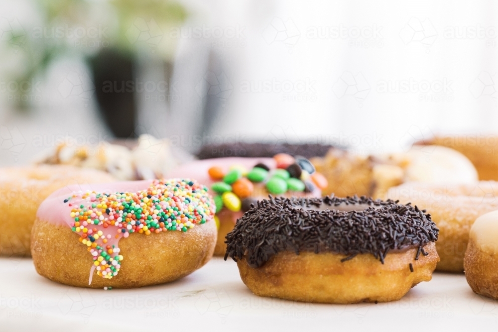 Horizontal shot of donuts with different toppings. - Australian Stock Image