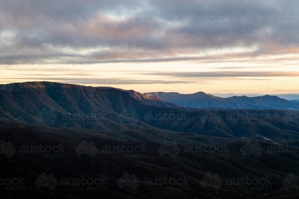 Horizontal shot of mountain ranges on a cloudy afternoon sky - Australian Stock Image