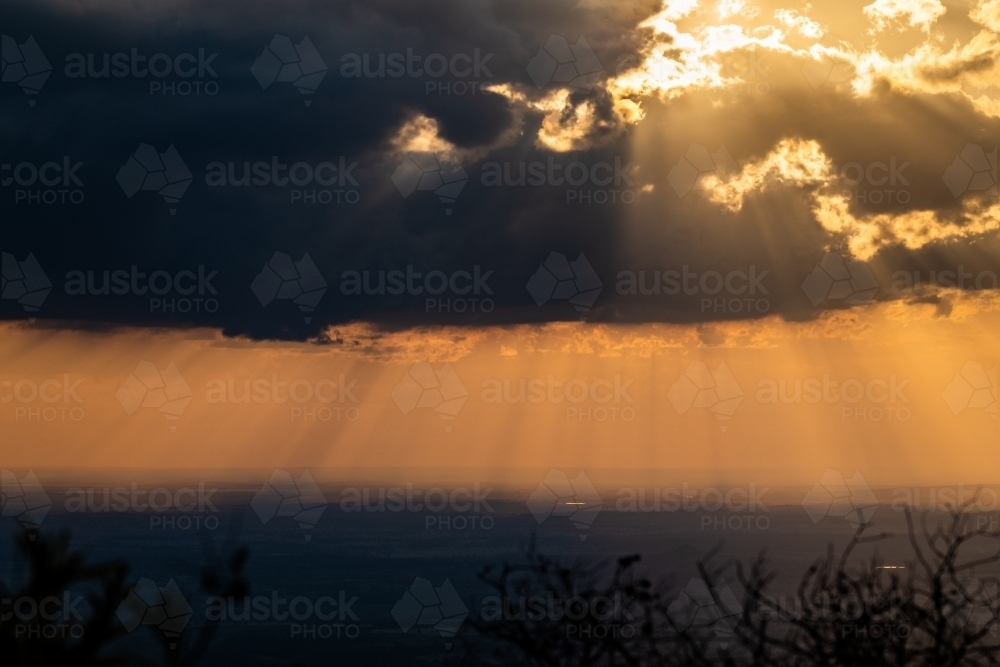 Horizontal shot of rays of sunlight shining through clouds - Australian Stock Image