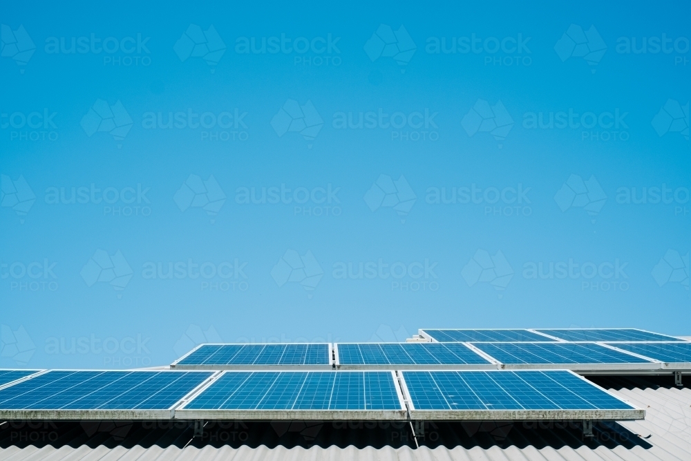 horizontal shot of solar panels with blue sky in the background - Australian Stock Image