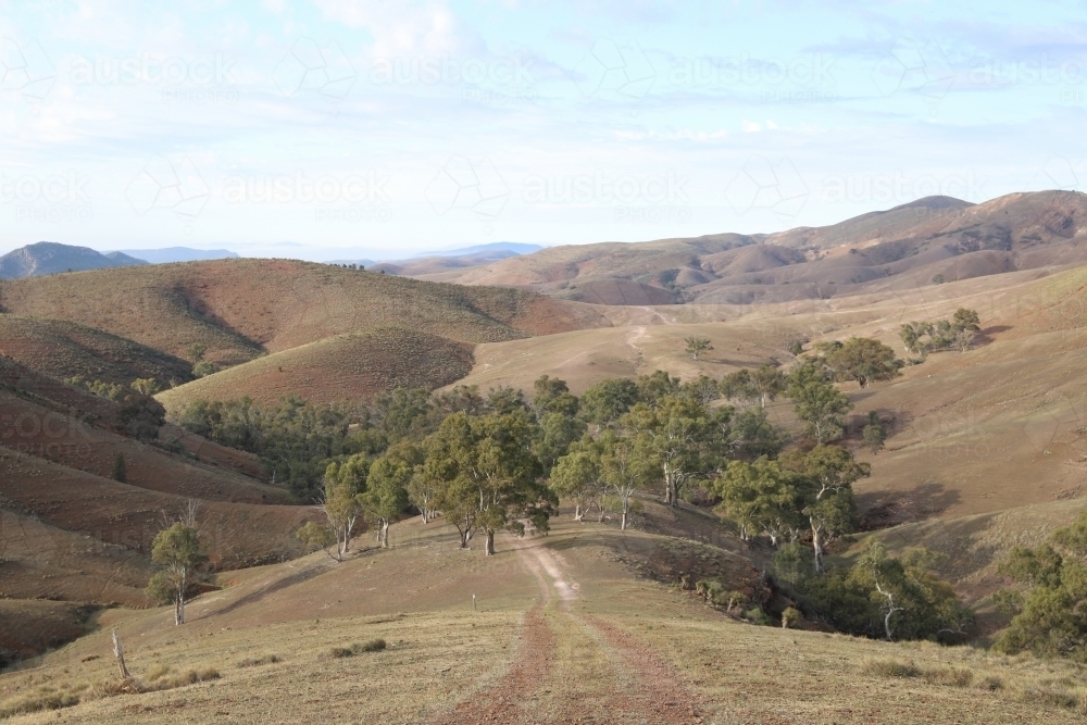 Landscape image looking along a pathway to hills and valleys and trees - Australian Stock Image