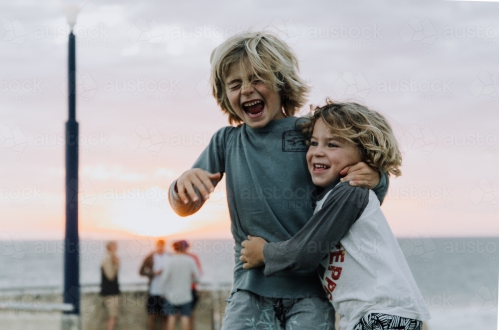 Horizontal shot of two kids on the beach having fun. - Australian Stock Image