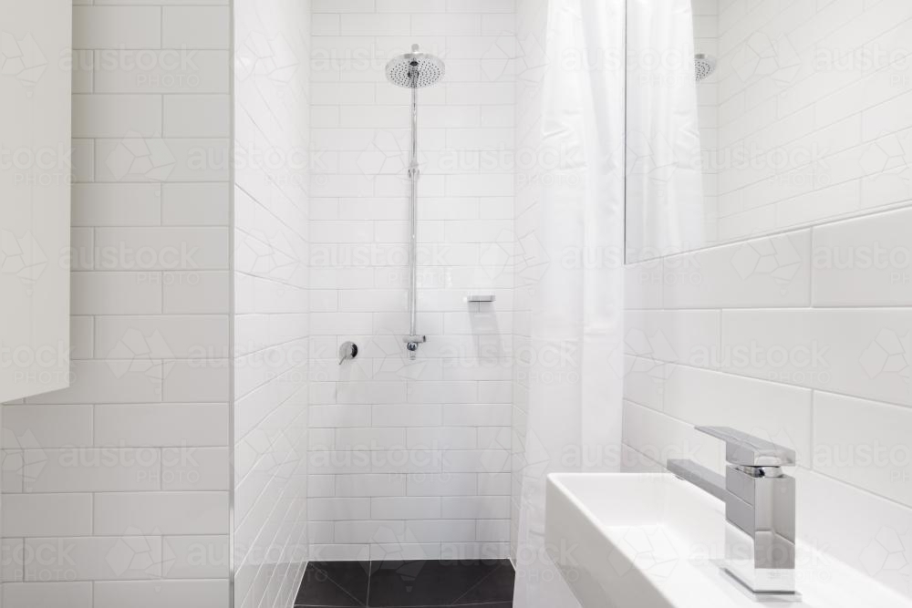Horizontal verion of crisp white ensuite bathroom in renovated home - Australian Stock Image
