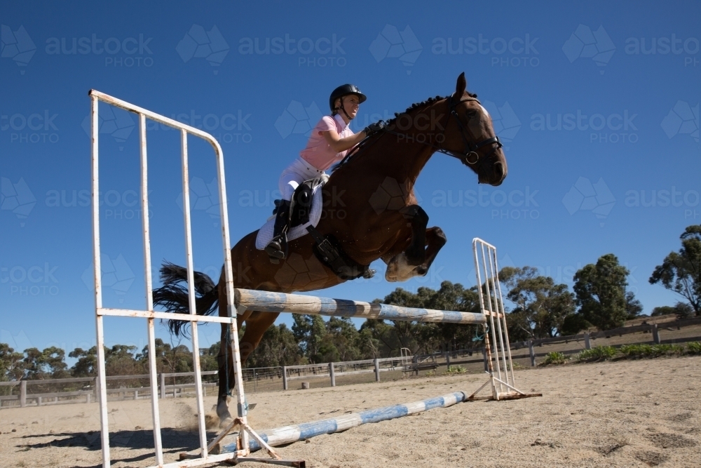 Horse and rider show Jumping in sand arena - Australian Stock Image