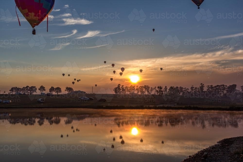 Hot air balloons reflected over lake - Australian Stock Image