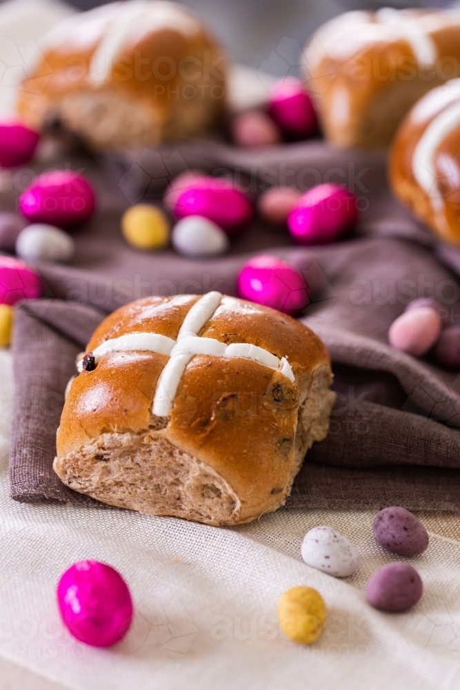 Hot cross bun at Easter with chocolate eggs - Australian Stock Image