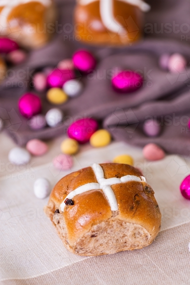 Hot cross bun at Easter with chocolate eggs - Australian Stock Image