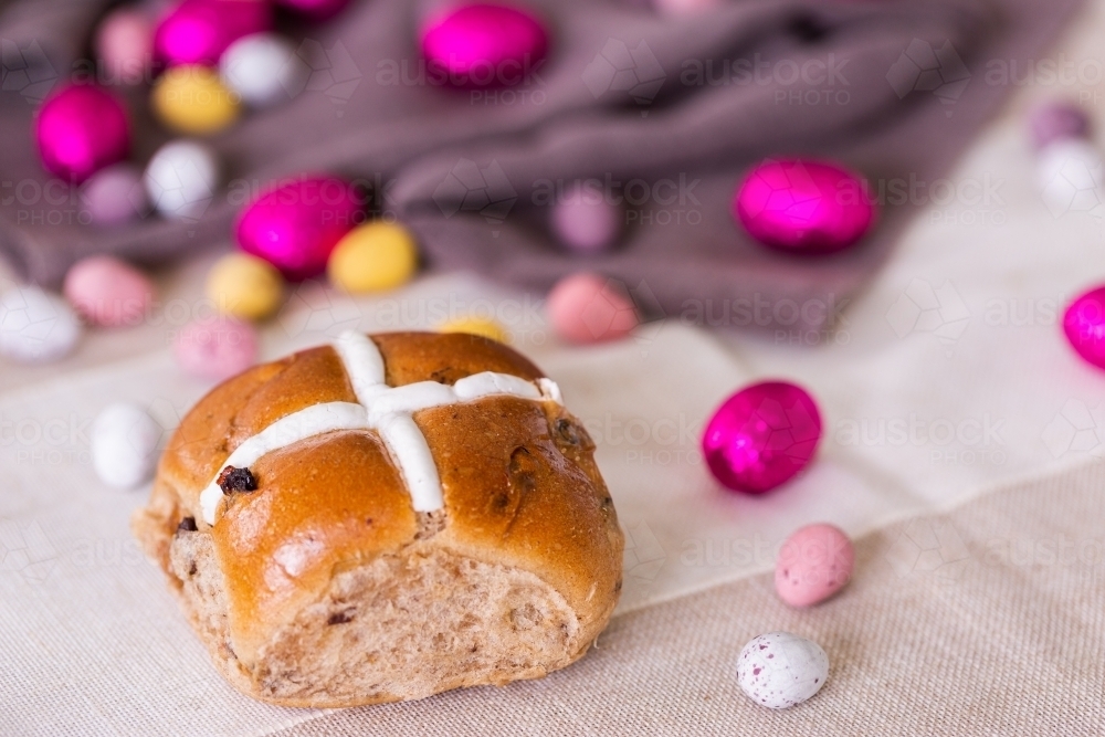 Hot cross bun at Easter with chocolate eggs - Australian Stock Image
