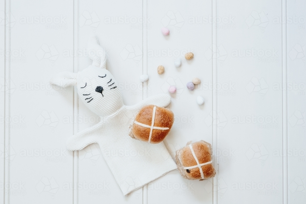 Hot cross buns, mini easter eggs and bunny rabbit on white background - Australian Stock Image