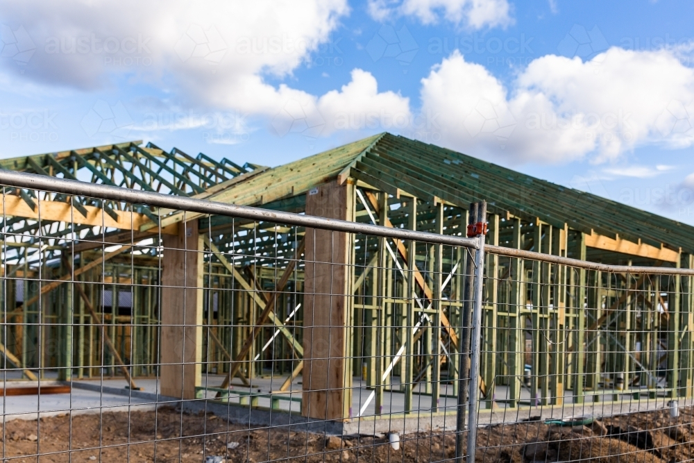 house being built with a timber frame behind temporary fencing - Australian Stock Image
