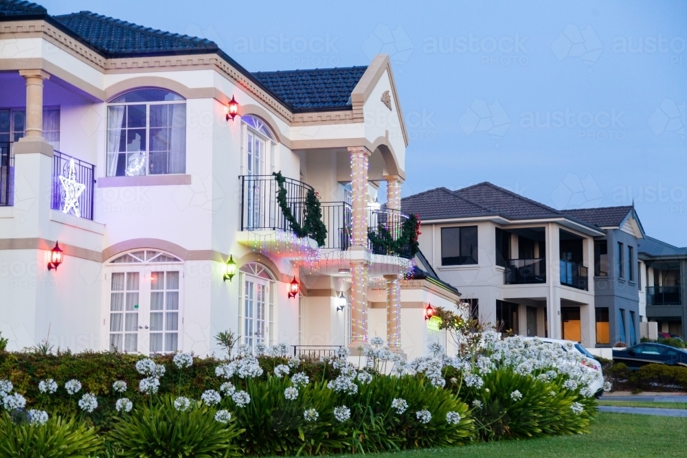 House on street corner at dusk with Christmas lights and decorations - Australian Stock Image