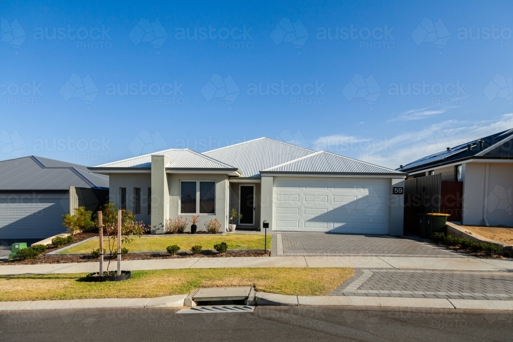 House with neat lawn and driveway to garage - Australian Stock Image