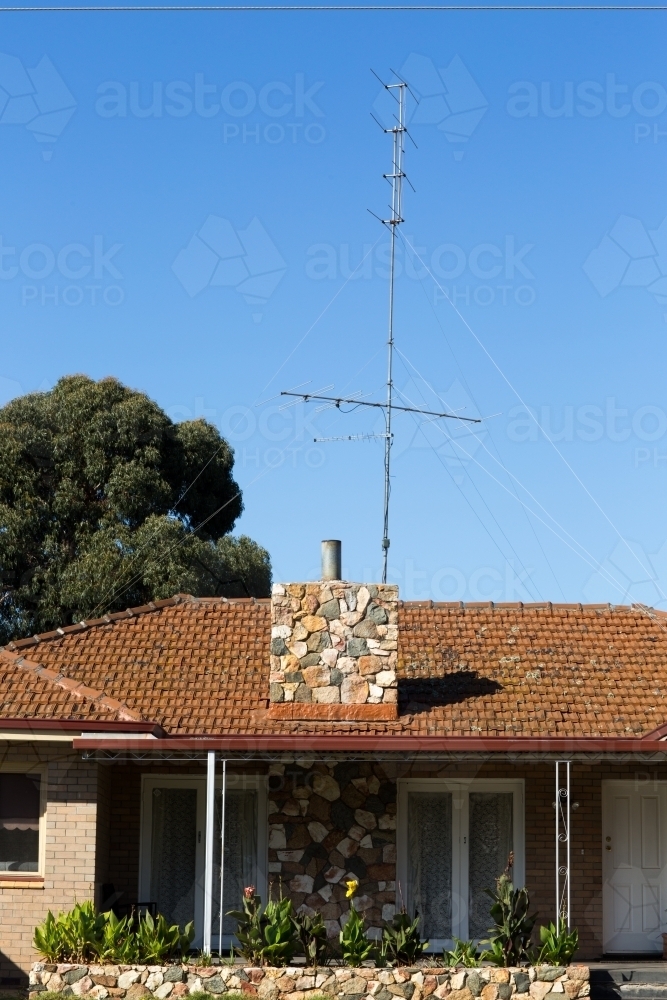 House with tiled roof and tall antenna - Australian Stock Image