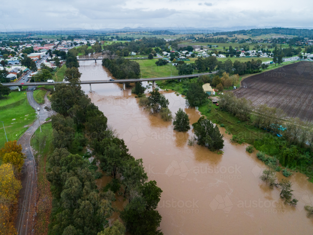 Hunter river in flood passing town of Singleton in Hunter Valley from aerial view on overcast day - Australian Stock Image